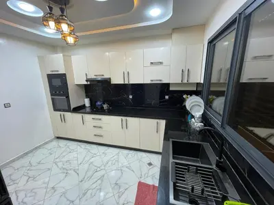a kitchen with white cabinets and black counter tops at Air-conditioned apartment Atlas star in Azrou