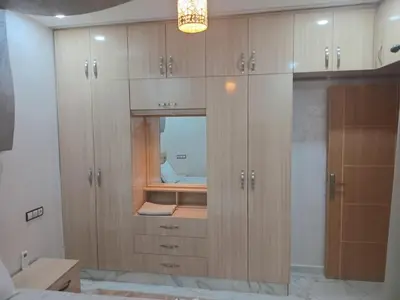 a large wooden cabinet with a mirror in a bedroom at Air-conditioned apartment Atlas star in Azrou