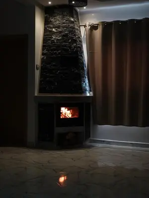 a fireplace in a living room with a stone wall at Air-conditioned apartment Atlas star in Azrou