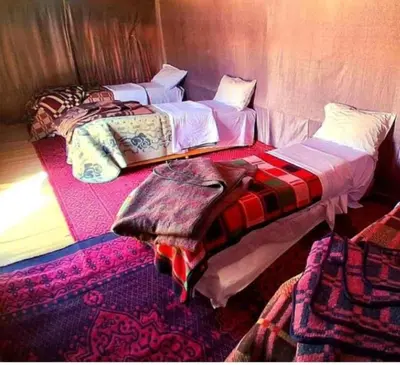 two beds sitting next to each other in a room at Chebbi Desert Camp in Merzouga