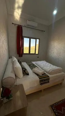 a large bed in a room with a window at Apartment with Pool & Kasbah View in Aït Ben Haddou