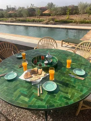 a green table with food and drinks on it next to a pool at Luxury VILLA - Pool-view Atlas-Ourika-Golfs in Akkara