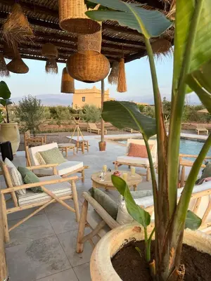 a patio with chairs and tables and a pool at Luxury VILLA - Pool-view Atlas-Ourika-Golfs in Akkara