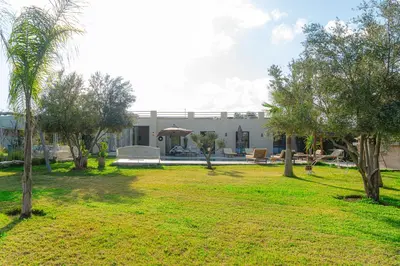 a house with a yard with trees in front of it at Maison soli Marrakech