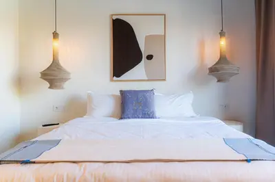 a bedroom with a white bed with a blue pillow at Maison soli Marrakech