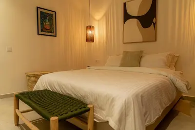 a bedroom with a large bed and a green bench at Maison soli Marrakech