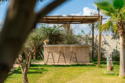 a set of three bar stools in a garden at Maison soli Marrakech