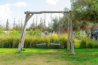 a wooden arch with two benches in a garden at Maison soli Marrakech