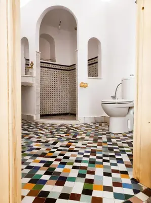 a bathroom with a checkered floor and a toilet at Riad Benkirane in Fès