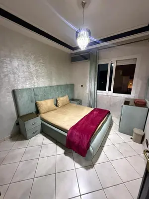 a bedroom with a bed with a purple blanket on it at basim swedin in Oulad Akkou