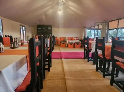a restaurant with tables and chairs and a dining room at Mirage Luxury Camp in Merzouga