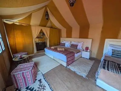 a bedroom with two beds and a tent at Mirage Luxury Camp in Merzouga