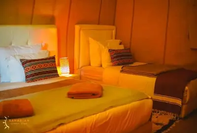 a room with two beds in a room with lights at Mirage Luxury Camp in Merzouga