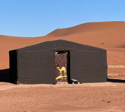 a hut in the desert with a skateboard in it at Tarrast Desert Camp in Mhamid