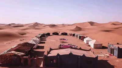 a group of huts in the middle of the desert at Excursion Erg chegaga in Mhamid