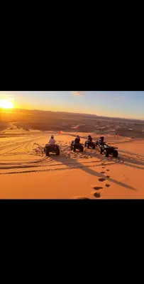 a group of people driving in the desert at Merzouga Desert Family Host tata- Hassi Labied Dunes View & Tours in Hassilabied