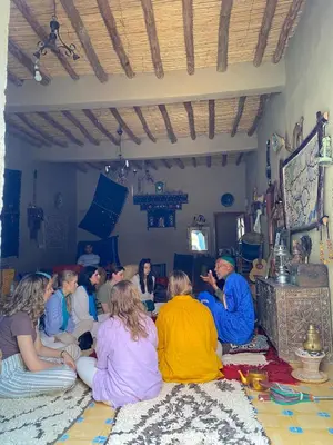 a group of people sitting on the floor in a room at Merzouga Desert Family Host tata- Hassi Labied Dunes View & Tours in Hassilabied