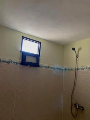 a bathroom with a shower and a window at Merzouga Desert Family Host tata- Hassi Labied Dunes View & Tours in Hassilabied