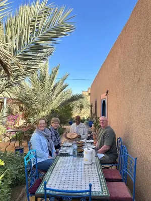 a group of people sitting at a table at Merzouga Desert Family Host tata- Hassi Labied Dunes View & Tours in Hassilabied