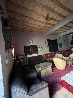 a living room with a couch and a table at Merzouga Desert Family Host tata- Hassi Labied Dunes View & Tours in Hassilabied