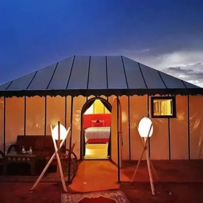 a tent with two lights and a bed in it at Africa Berber Camp in Merzouga