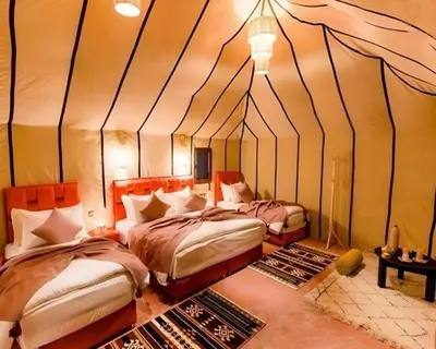a bedroom with two beds in a tent at Africa Berber Camp in Merzouga