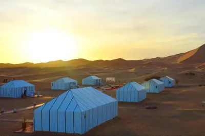 a group of white buildings in the desert at Africa Berber Camp in Merzouga