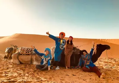 a group of people standing in the desert at Solaris Luxury Camp in Merzouga