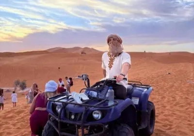 a man on a quad bike in the desert at Solaris Luxury Camp in Merzouga