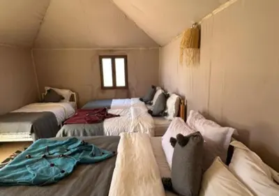 a room with four beds in a tent at Solaris Luxury Camp in Merzouga