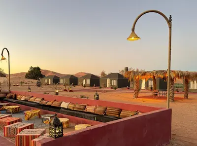 a row of tables and benches with a street light at Big Dipper Luxury Camp in Merzouga