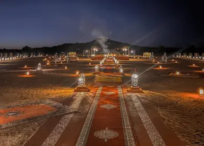 a view of a park at night with lights at Big Dipper Luxury Camp in Merzouga