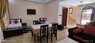 a living room with a table and chairs and a couch at Hôtel Ajil Cascades D'ouzoud in Ouzoud