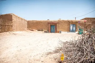 a building in the desert with a blue door at Oasis travel in Ksar Tazouga
