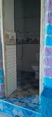 a bathroom with a toilet and a tiled floor at Oasis travel in Ksar Tazouga