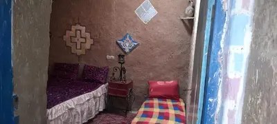a small bedroom with a bed and a chair at Oasis travel in Ksar Tazouga