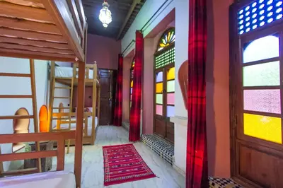 a corridor of a house with colorful windows and a door at Riad Dar Mansoura in Fès