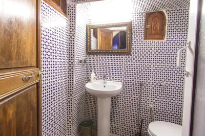 a bathroom with a sink and a toilet and a mirror at Riad Dar Mansoura in Fès