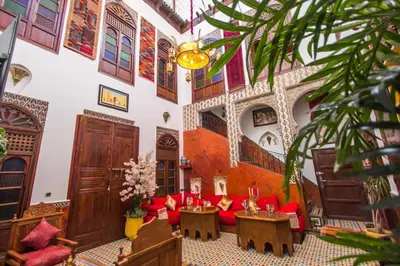 a living room with red furniture in a building at Riad Dar Mansoura in Fès