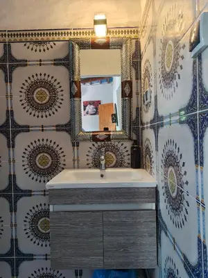 a bathroom with a sink and a mirror at Le Retour au calme Maison d'hôtes in Tinerhir