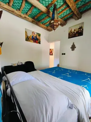 a bedroom with a bed in a room with a ceiling at Le Retour au calme Maison d'hôtes in Tinerhir