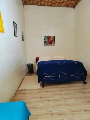 a bedroom with a bed with a blue sheet on it at Le Retour au calme Maison d'hôtes in Tinerhir
