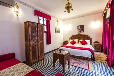 a bedroom with a bed and a table in a room at Riad Dar Bab Guissa in Fès