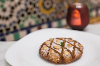 a pastry on a white plate on a table at Riad Dar Bab Guissa in Fès