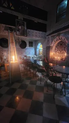 a restaurant with tables and chairs in a room at Riad Royal in Meknès
