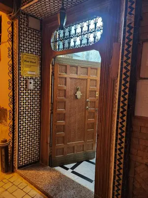 a wooden door in a hallway with a window at Riad Royal in Meknès