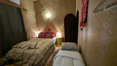 a bedroom with a bed and two pillows in it at Riad Amar in Merzouga