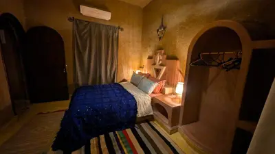 a bedroom with a bed and a tv in it at Riad Amar in Merzouga