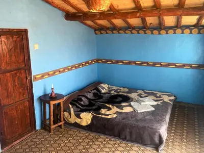 a bedroom with a bed in a blue room at Desert Tours & Camp Chraika in Mhamid