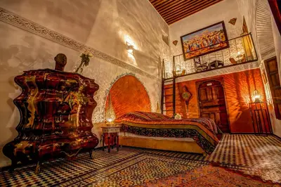 a bedroom with a bed and a chair in it at Riad Almaz in Fès